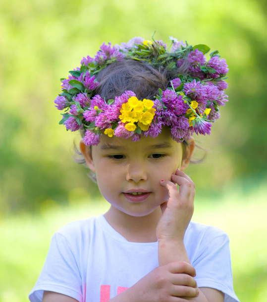 Retrato de una chica alegre con una corona de flores en la cabeza
 - Foto, imagen