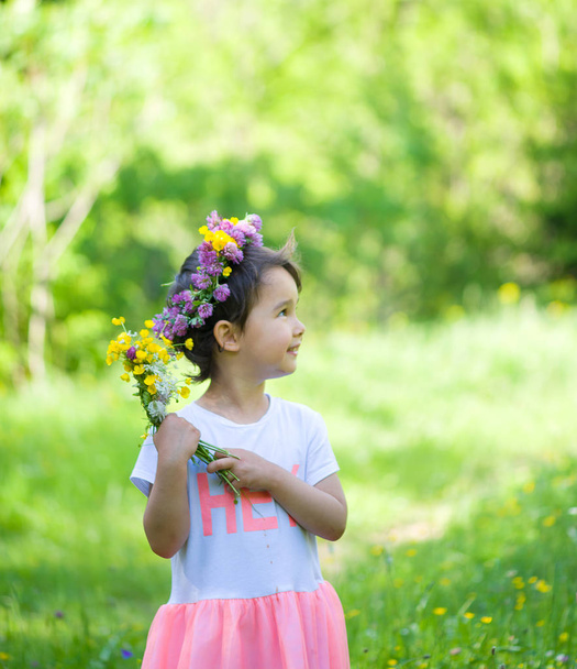 Retrato de una chica alegre con una corona de flores en la cabeza
 - Foto, Imagen
