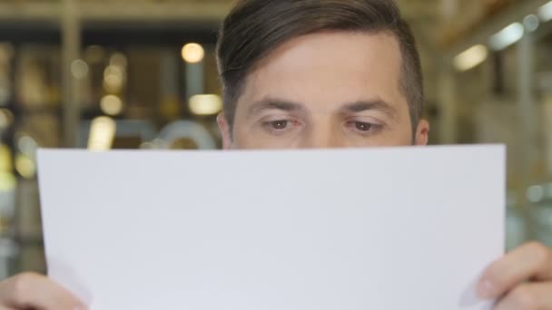 man looking on paper and smiling - Video, Çekim