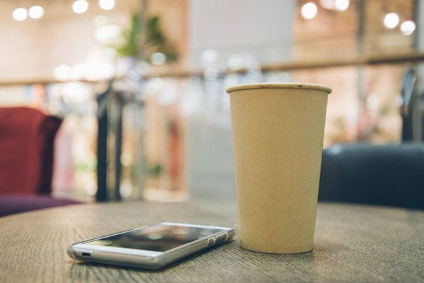 чашка кофе с мобильным телефоном на столе
 - Фото, изображение