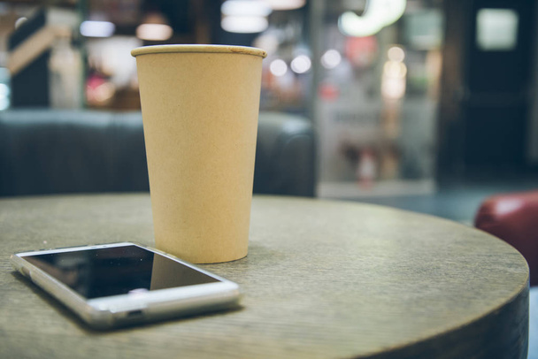 φλιτζάνι καφέ με το κινητό στο τραπέζι - Φωτογραφία, εικόνα