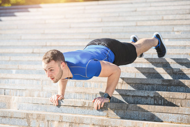 Fit man doing exercises outdoors at park - Photo, Image