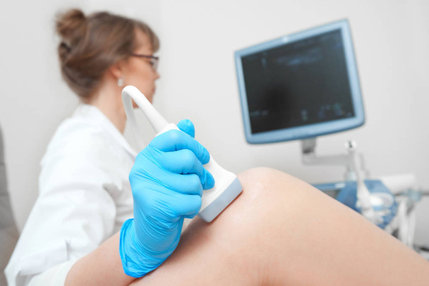 Woman getting knee ultrasound scanning examination at the clinic - Фото, зображення
