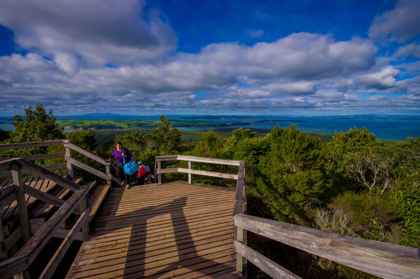 AUCKLAND, NEW ZEALAND- MAY 12, 2017: Unidentified people enjoying the beautiful view from top in the mountain in Rangitoto Island walking in wooden paths, New Zealand in a sunny day - Fotografie, Obrázek