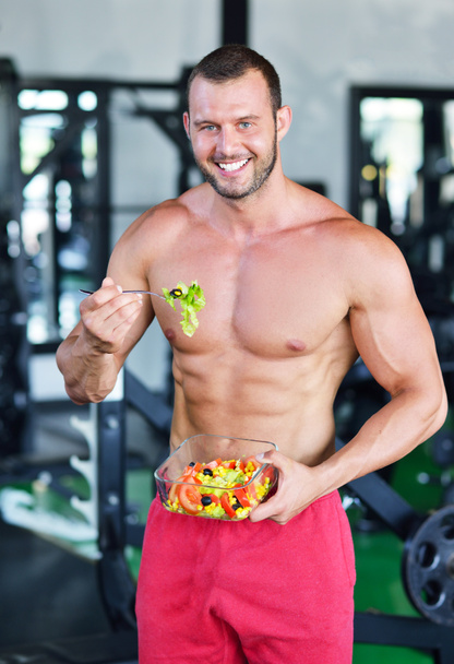 Αθλητικός άνδρας με υγιεινή σαλάτα στο γυμναστήριο - Φωτογραφία, εικόνα
