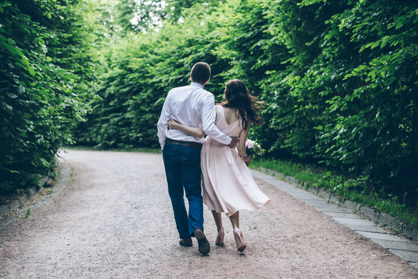mies ja nainen kävelemässä puistossa tyylikkäässä mekossa
 - Valokuva, kuva