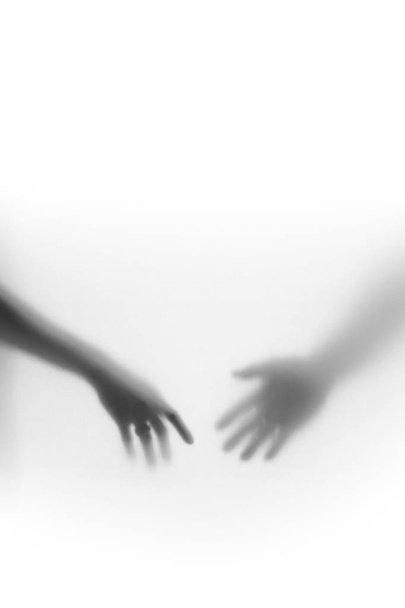 Male and female hands silhouette, almost touch each-other - Photo, image