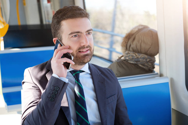 Businessman commuter is traveling and is talking   - Photo, Image