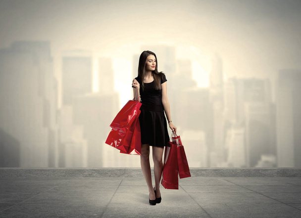 Kırmızı alışveriş çantalı zarif şehir kızı. - Fotoğraf, Görsel