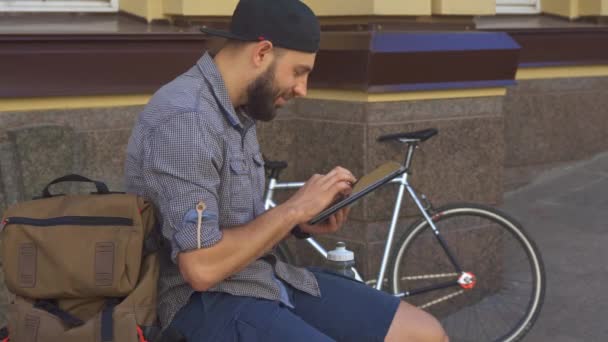 Cyklista využívá tabletu na ulici - Záběry, video