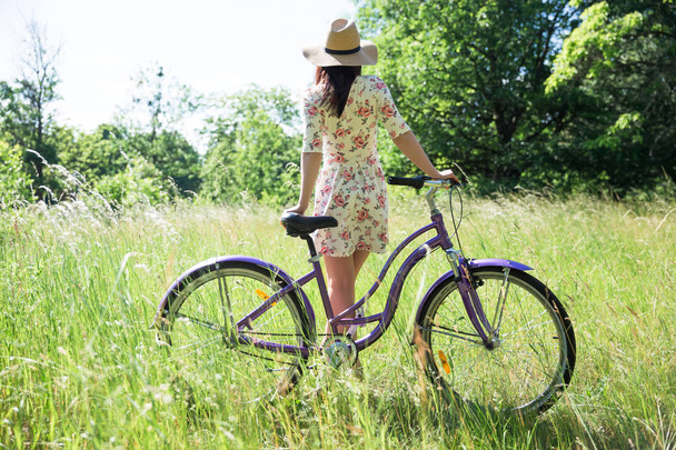 schöne Frau mit Fahrrad im Stadtpark. schöne Natur. - Foto, Bild