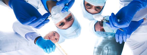Surgeons team, woman wearing protective uniforms,caps and masks - Fotografie, Obrázek