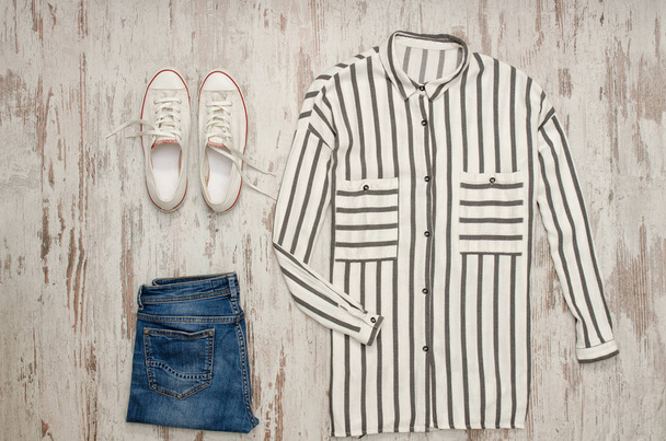 Beyaz çizgili gömlek, beyaz spor ayakkabı ve kot pantolon. Moda kavramı - Fotoğraf, Görsel
