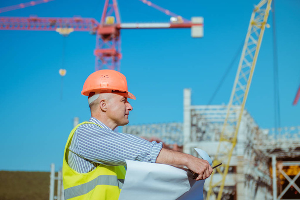 Portrait of a male engineer on a construction site background - Foto, afbeelding