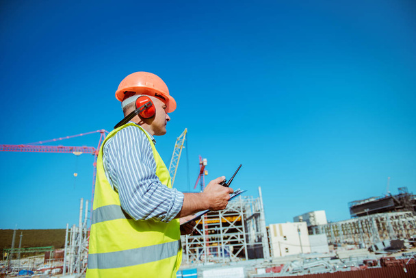 Portrait of a male engineer on a construction site background - Fotó, kép