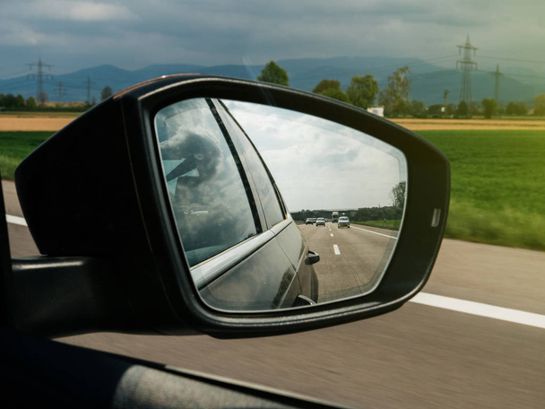 Hegyek és autók és látható a visszapillantó tükör az autópálya egy - Fotó, kép