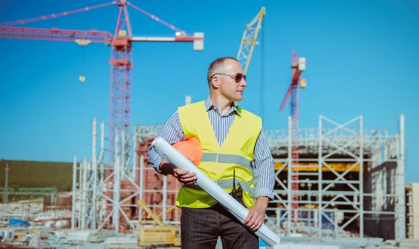 Portrait of a male engineer on a construction site background - Foto, afbeelding