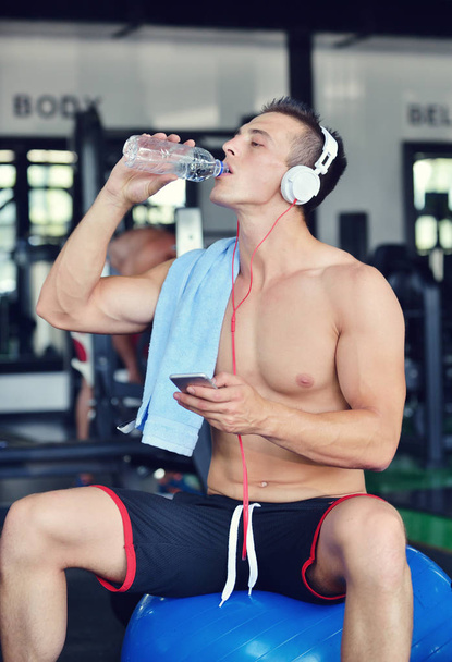 człowiek w Odzież sportowa słuchania muzyki w siłowni - Zdjęcie, obraz