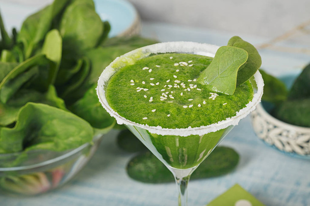 Green spinach and cucumber smoothie on light blue wooden backgro - Photo, Image