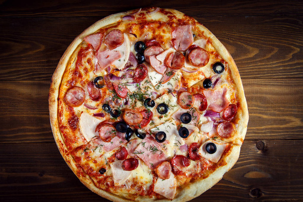 Delicious homemade pizza with mozzarella, ham, olives and fennel - Фото, зображення