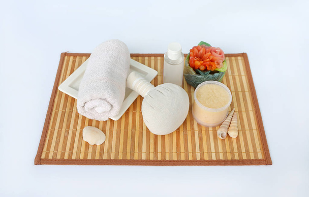 Spa herbal compressing ball with towels and Salt Scrub, Spa concept on bamboo board against white background - Фото, изображение