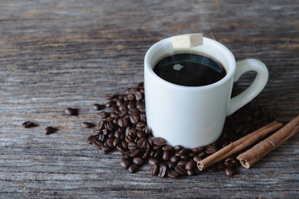 Brązowy cukier kostka popadania w kubek gorącej kawy z ziaren kawy  - Zdjęcie, obraz