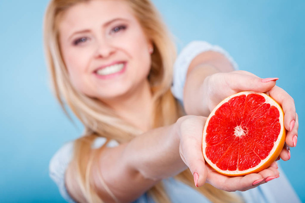 Woman holds grapefruit citrus fruit in hands - Foto, Imagen