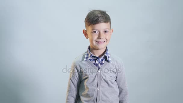 Little boy with toothless smile is wearing a cap - Filmagem, Vídeo