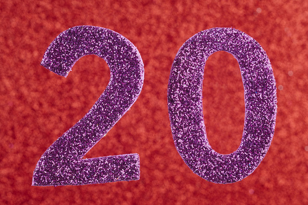 Número veinte púrpura sobre fondo rojo. Aniversario
. - Foto, imagen