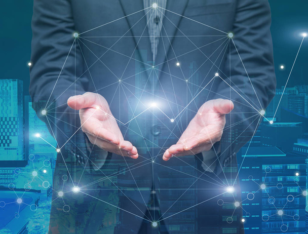 Businessman hand holding the futuristic network connection technology on cityscape background, double exposure, business technology and Social Network concept - Photo, Image