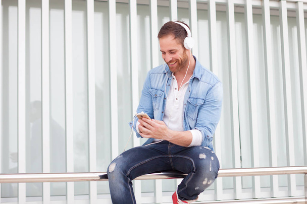 Hombre casual escuchando música al aire libre
 - Foto, Imagen