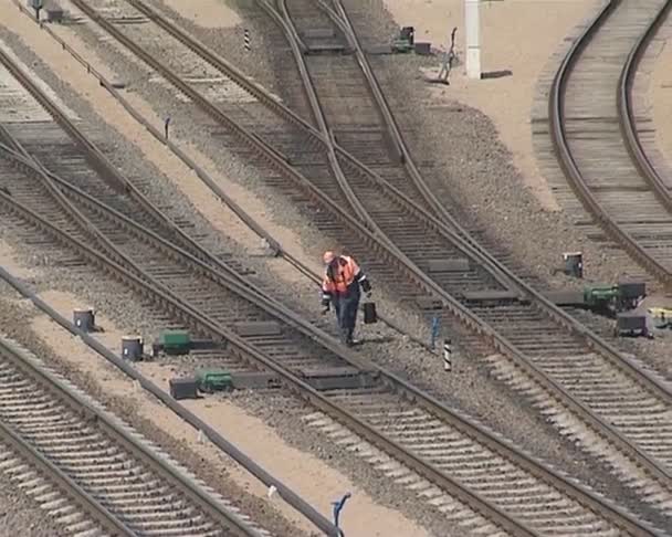 de man op zoek na de trein tracks en een trein lopend. - Video