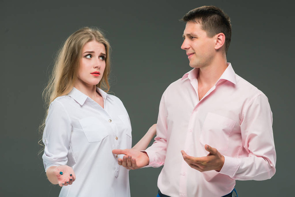 Portrait of a young couple standing against gray background - Photo, image