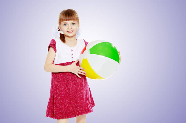 Little girl is playing with a ball. - Foto, imagen