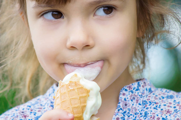 The child eats ice cream. Selective focus. - Photo, Image