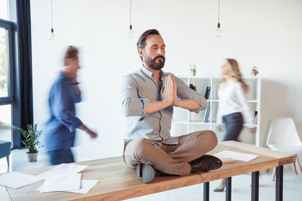 Businessman meditating in office  - Фото, зображення
