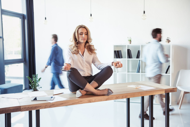 Businesswoman meditating in office  - Photo, Image