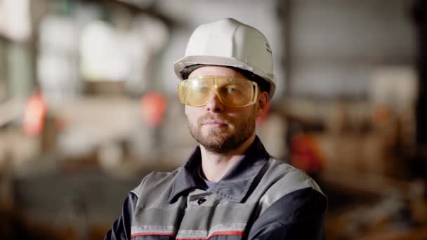 A builder at a construction site. A man dressed in a special uniform and wearing a helmet on his head at the construction site of the shop for the manufacture. - Footage, Video