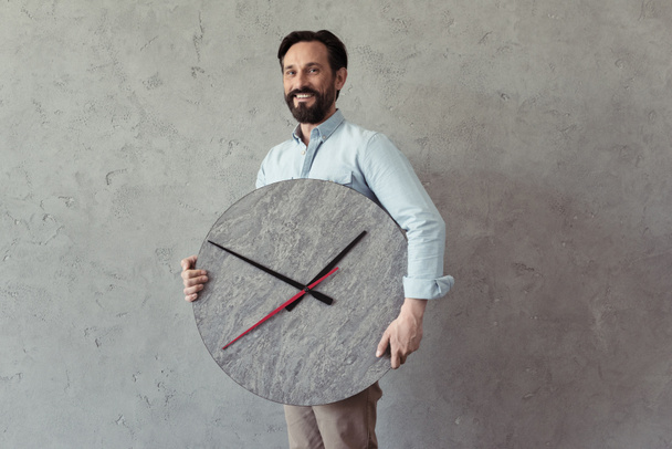smiling mature man holding clock - Fotoğraf, Görsel