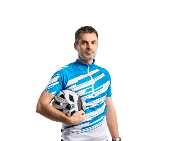Mature man in sports t-shirt and helmet. Studio shot, isolated. - Photo, Image