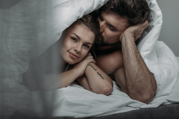casal feliz sob cobertor
 - Foto, Imagem