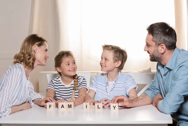 smiling family sitting at table - Fotó, kép