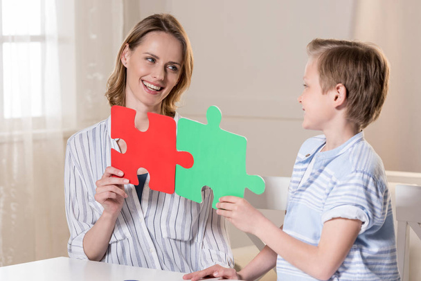 Mother with son holding puzzle - Zdjęcie, obraz