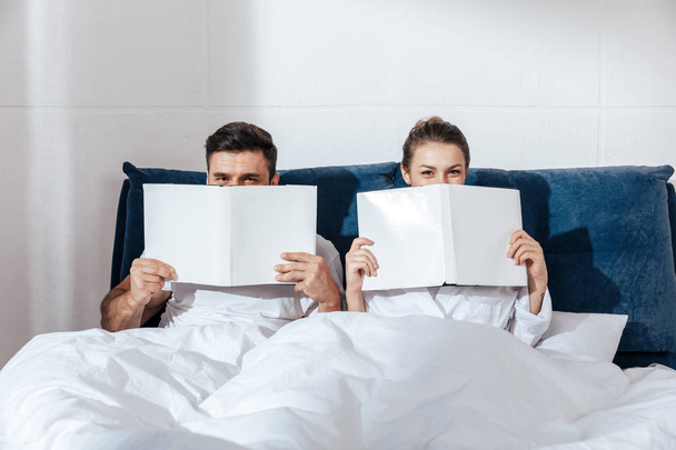 couple reading in bed - Фото, зображення