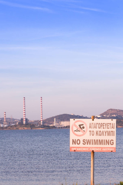 Немає купання знак на пляжі, з електростанції станції у фоновому режимі. Лавра, Греція. - Фото, зображення