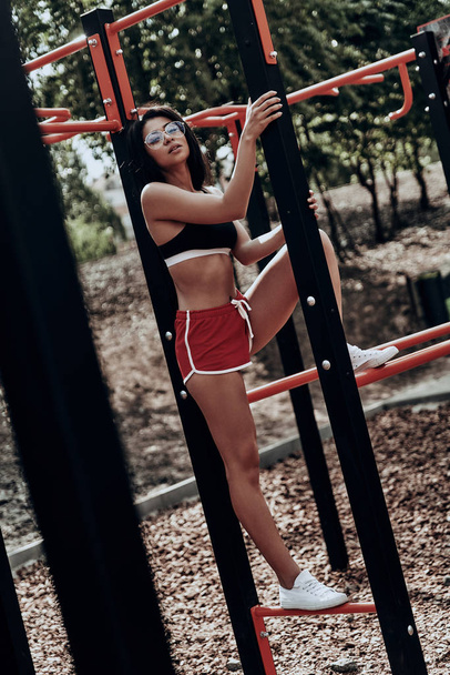 sporty woman standing on horizontal bars - Zdjęcie, obraz