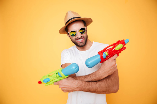 Happy young man holding toy water guns. - Foto, Imagen