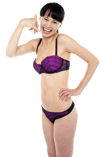 Attractive brunette in bikini gesturing a mock call - Zdjęcie, obraz