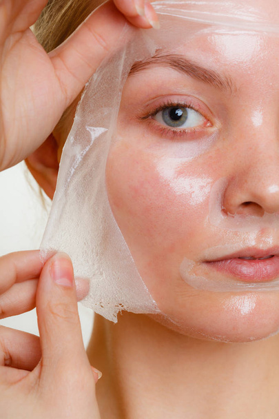 Woman removing facial peel off mask. - Photo, image