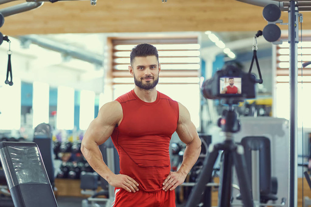 Blogger athlete bodybuilder makes a video in the gym - Valokuva, kuva